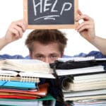 - SoundEnglish alt="a student's head visible behind a hug stack of notesbooks, holding a small chalkboard over his head that reads, help!"